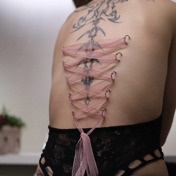 Gorsetowy piercing pleców z różową wstążką