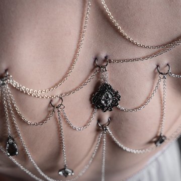 Piercing gorsetowy na plecach z łańcuszkami