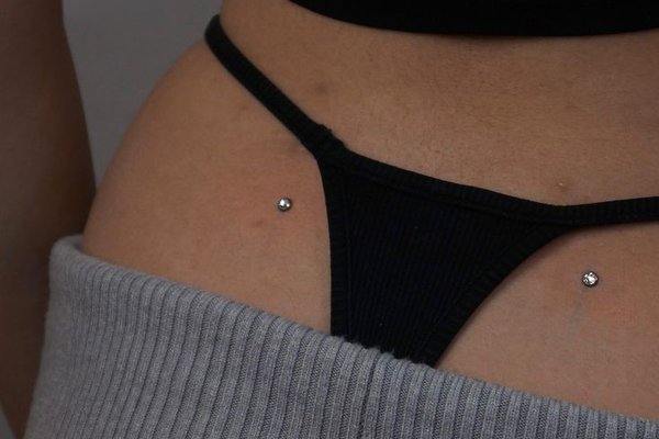 Dwa microdermale na dolnej części pleców