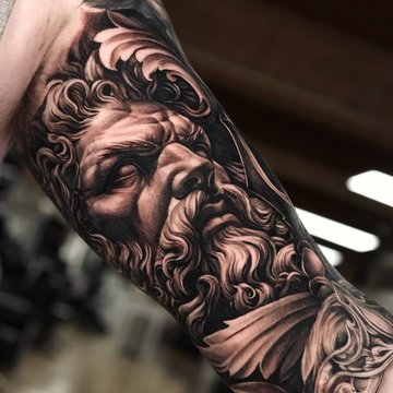 Tatuaż Zeus na bicepsie mężczyzny