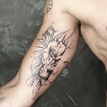 Tatuaż lew w stylu szkicowym na bicepsie mężczyzny