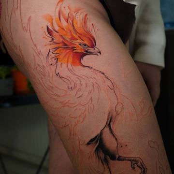 Konturowy tatuaż ptaka na udzie, płomienny pióropusz