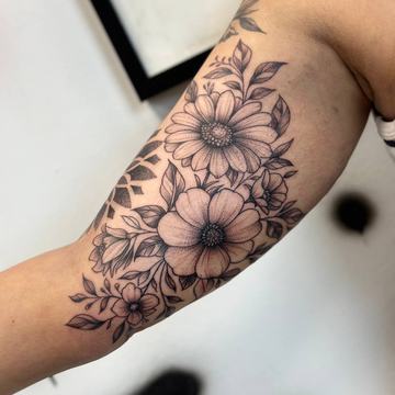 Kontrastowy tatuaż kwiatów na wewnętrznym ramieniu
