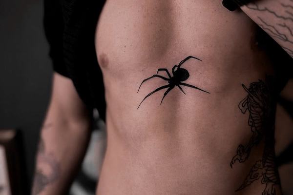 Czytelny tatuaż pająka na klatce piersiowej