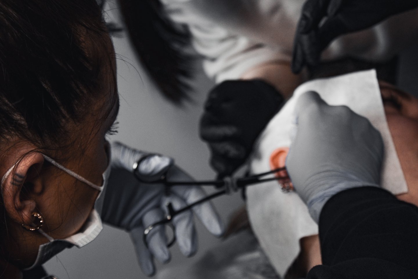 Piercer wykonuje Orbital Piercing w salonie