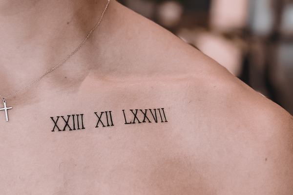 Tatuaż: cyfry rzymskie przy obojczyku