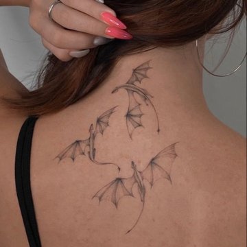 Delikatny smok w stylu fine line na na plecach