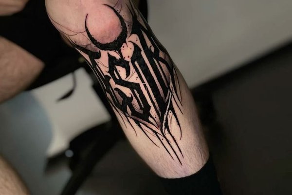 Czarny tatuaż abstrakcyjny na nodze