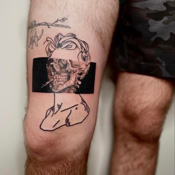 Tatuaż męski na udzie z czaszką i liniowym szkicem
