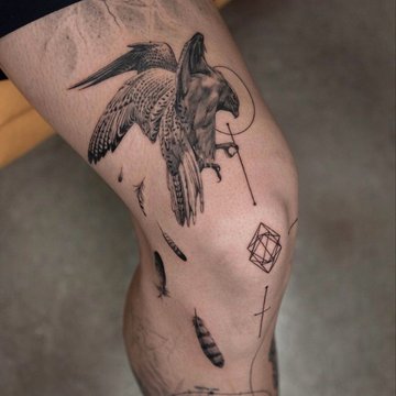 Realistyczno-geometryczny tatuaż męski na nodze z motywem ptaka