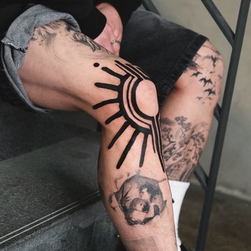 Męski tatuaż na nodze z grubymi czarnymi liniami i realistycznym motywem