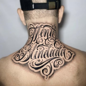 Tatuaż na karku z napisem „Mente Blindada” ozdobnym fontem