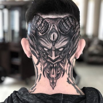 Tatuaż na karku i głowie przedstawiający demoniczną maskę z rogami