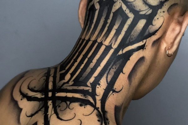 Tatuaż na karku w stylu blackwork z ozdobnym napisem i cieniowaniem