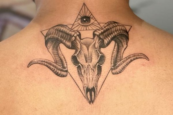 Tatuaż na karku przedstawiający czaszkę z rogami w trójkącie z okiem