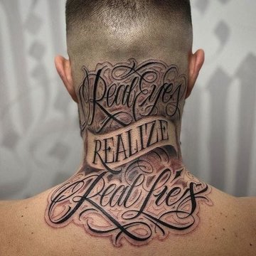 Tatuaż na karku z napisem „Real eyes realize real lies” ozdobnym fontem