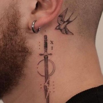 Tatuaż za uchem męski – miecz z geometrycznymi elementami i jaskółką