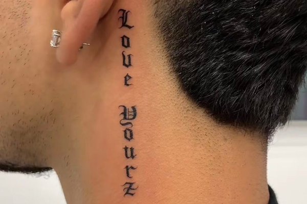 Tatuaż za uchem męski – napis Love Yourz