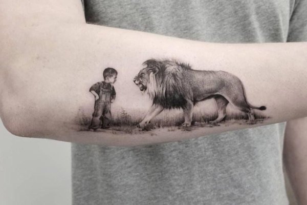 Tatuaż na nadgarstku męski z lwem i dzieckiem w stylu realistycznym