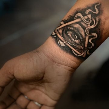 Tatuaż na nadgarstku męski z okiem w trójkącie w stylu realistycznym