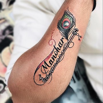 Tatuaż pióra z imieniem na przedramieniu