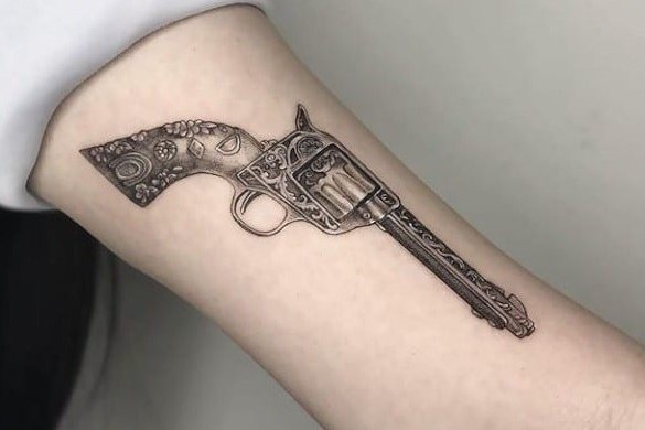 Realistyczny damski pistolet jako tatuaż