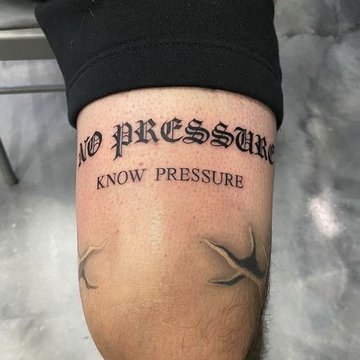 Tatuaż na udzie męski - napis w gotyckim stylu