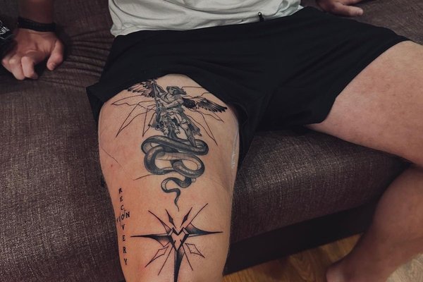 Tatuaż na udzie męski – archanioł walczący z wężem i symboliczna gwiazda