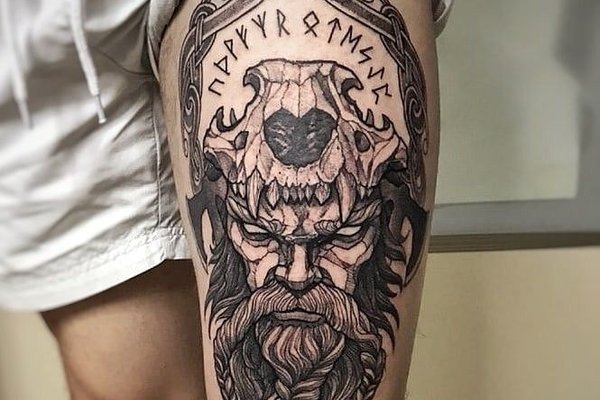 Tatuaż na udzie męski – wiking z runami i czaszką wilka w nordyckim stylu