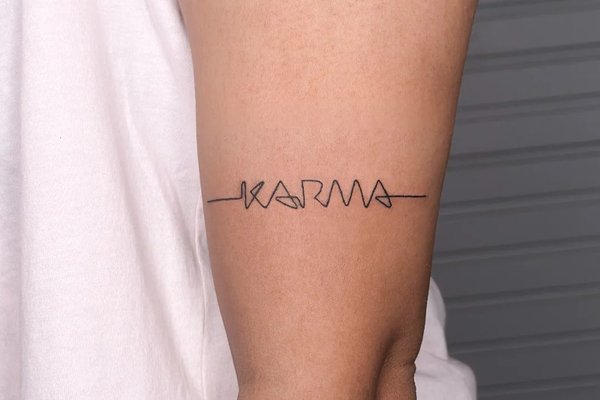 tatuaż karma na ramieniu