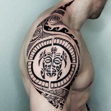Tatuaż męski na barku - polinezyjski wzór z maską tiki
