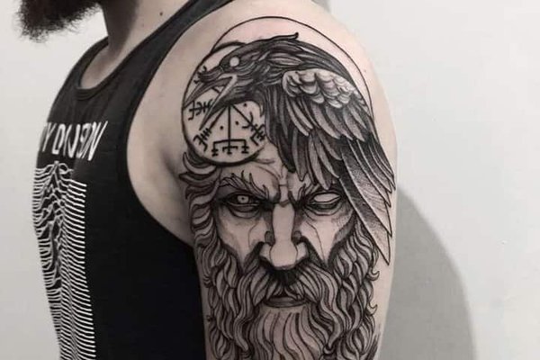 Tatuaż męski na barku – nordycki bóg Odin z krukiem i runami