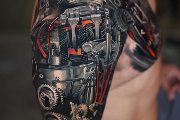 Tatuaż na ramieniu męski w stylu biomechanicznym