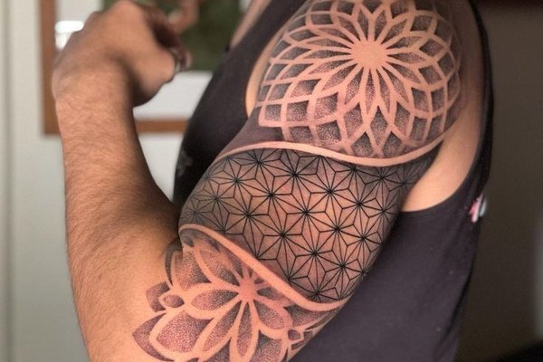 Tatuaż na ramieniu męski geometryczny z motywem mandali