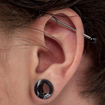 Industrial piercing ucha: pozioma sztanga w chrząstce