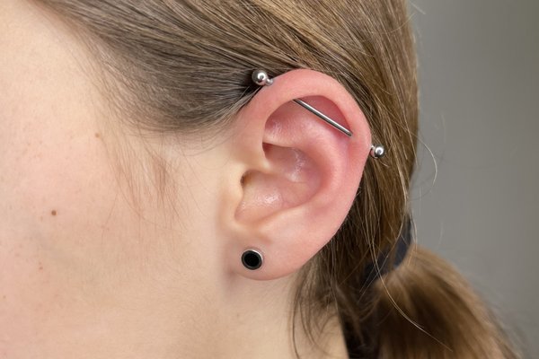 Srebrny piercing industrial w górnej części ucha