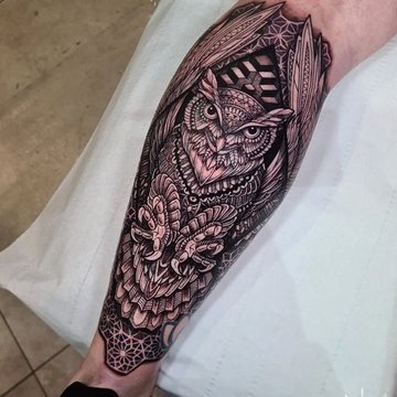 Tatuaż męski na łydce z sową w stylu geometrycznym