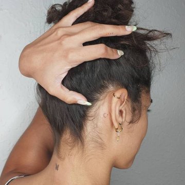 Małe tatuaże motyla na karku kobiety