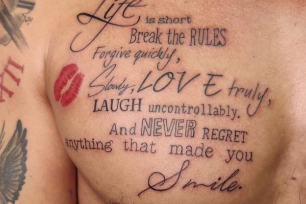 Tatuaż na klatce piersiowej męski  napis  z czerwonym pocałунком