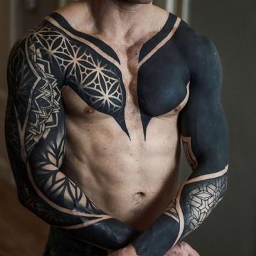 Tatuaż na klatce piersiowej męski – geometryczny blackout z symetrycznym wzorem