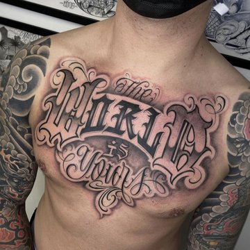 Tatuaż na klatce piersiowej męski  w stylu chicano lettering