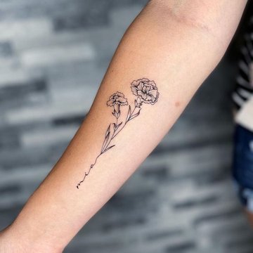 Goździk z napisem jako tatuaż