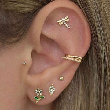 Ucho z kilkoma piercingami, w tym Flat