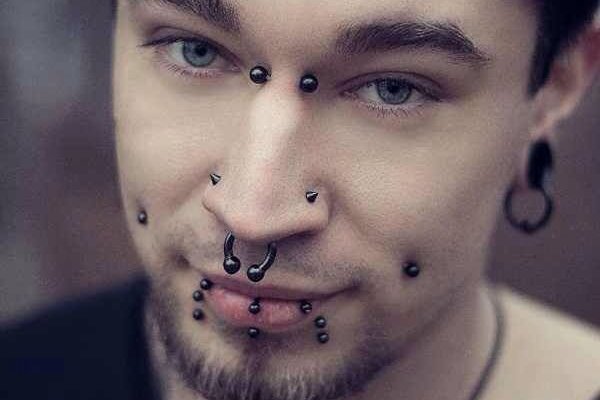 Osoba z bridge piercingiem między oczami i septum