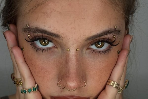 Złoty piercing bridge na grzbiecie nosa