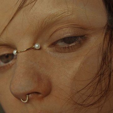 Zbliżenie: bridge piercing z perłami i septum