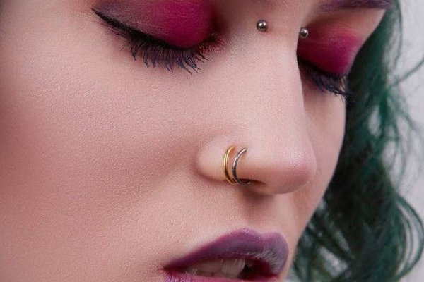 Zbliżenie twarzy z bridge piercingiem między oczami