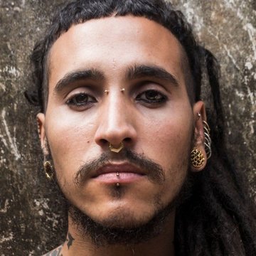 Stylowy srebrny bridge piercing na twarzy.