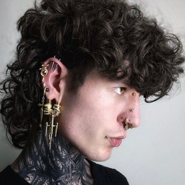 Metaliczny piercing bridge nad grzbietem nosa.