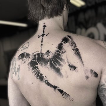 Tatuaż męski na plecach  rycerz z mieczem w stylu blackwork